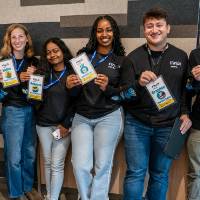 Group of Rep4 students holding up their event lanyards